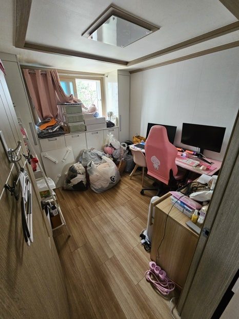 작업 후의 핑크톤 작업방, 게이밍 의자와 듀얼모니터 책상이 드러나고 정리된 마대 두 개만 남은 상태